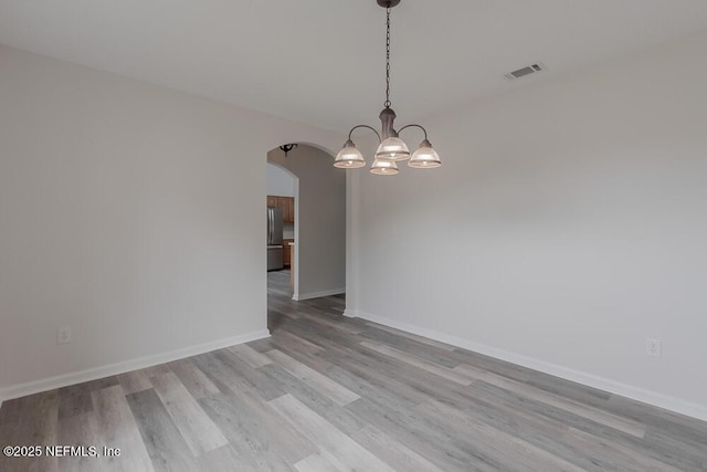 1203 Summer Springs Dr, Middleburg, FL 32068 - unfurnished room with arched walkways, light wood-type flooring, and a chandelier