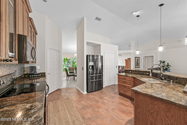 213 Seamist Ct, Ponte Vedra Beach, FL 32082 - kitchen with stainless steel appliances, brown cabinets, backsplash, light wood-style floors, and hanging light fixtures