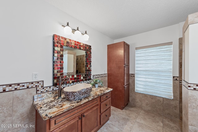 213 Seamist Ct, Ponte Vedra Beach, FL 32082 - full bathroom featuring tile walls, vanity, a wainscoted wall, tile patterned flooring, and a textured ceiling