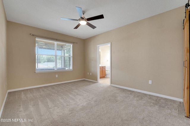25122 Chipshot Ct, Sorrento, FL 32776 - spare room featuring a barn door, light carpet, and a ceiling fan