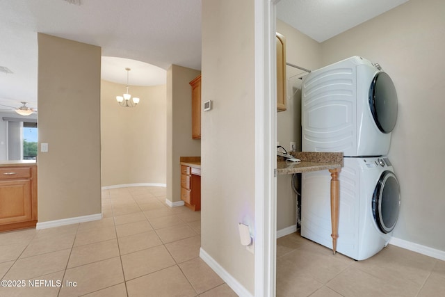 25122 Chipshot Ct, Sorrento, FL 32776 - laundry area featuring stacked washer and clothes dryer, light tile patterned floors, a ceiling fan, and a chandelier