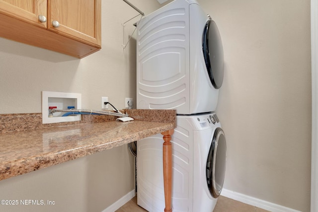 25122 Chipshot Ct, Sorrento, FL 32776 - laundry area featuring stacked washer / drying machine, cabinet space, and light tile patterned floors
