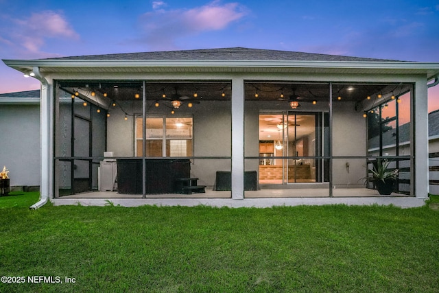 25122 Chipshot Ct, Sorrento, FL 32776 - back of property at dusk with a yard, a sunroom, and roof with shingles