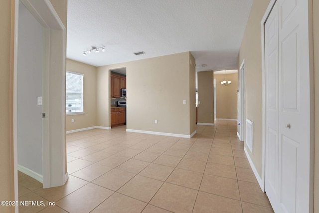 25122 Chipshot Ct, Sorrento, FL 32776 - spare room with light tile patterned floors, a chandelier, and a textured ceiling