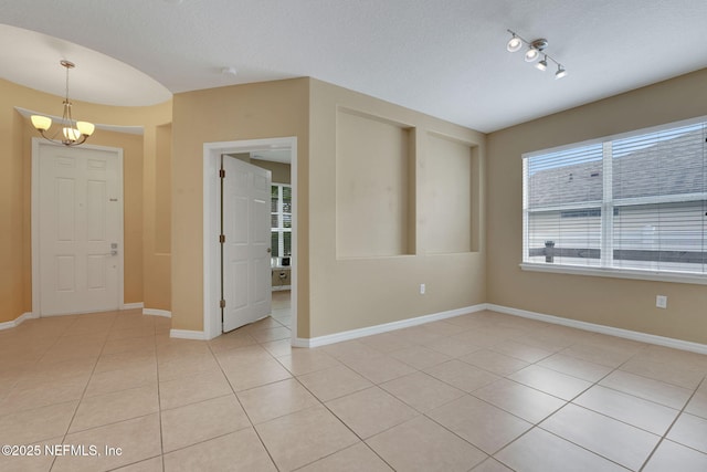 25122 Chipshot Ct, Sorrento, FL 32776 - unfurnished room featuring a chandelier, light tile patterned floors, rail lighting, and a textured ceiling