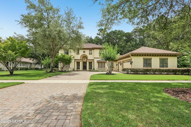 2645 Oakgrove Ave, Saint Augustine, FL 32092 - mediterranean / spanish-style house with stucco siding, decorative driveway, an attached garage, and a front yard