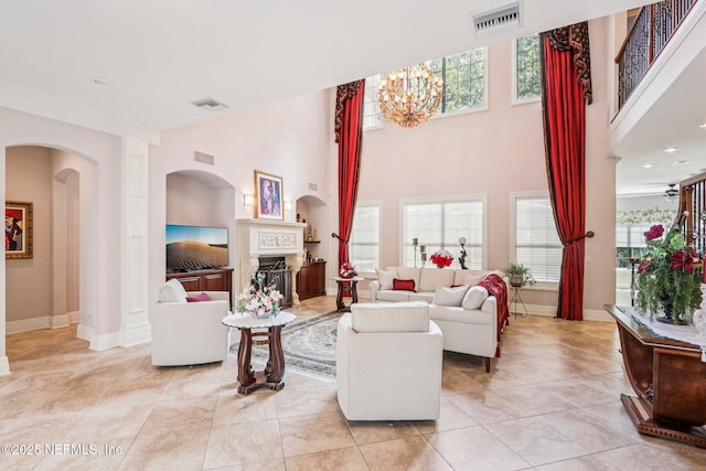 2645 Oakgrove Ave, Saint Augustine, FL 32092 - living room featuring a fireplace, a chandelier, arched walkways, light tile patterned floors, and a high ceiling