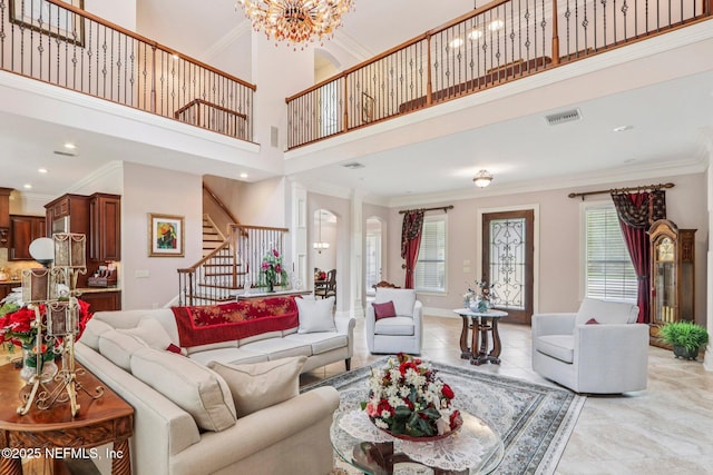 2645 Oakgrove Ave, Saint Augustine, FL 32092 - living room featuring stairway, crown molding, a towering ceiling, a chandelier, and light tile patterned floors