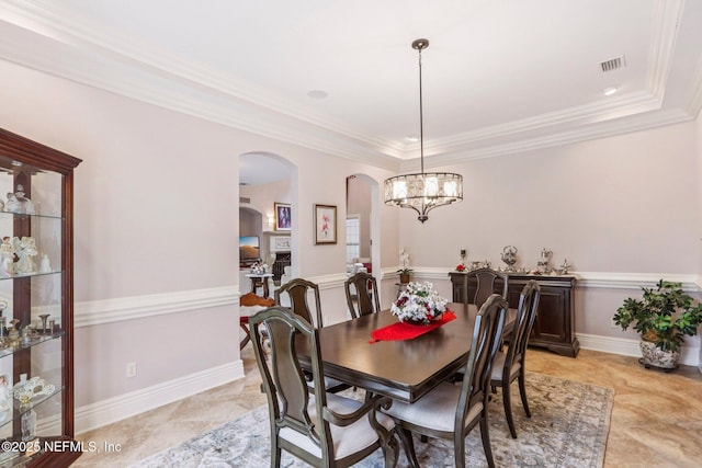 2645 Oakgrove Ave, Saint Augustine, FL 32092 - dining room featuring arched walkways, a chandelier, ornamental molding, and a raised ceiling