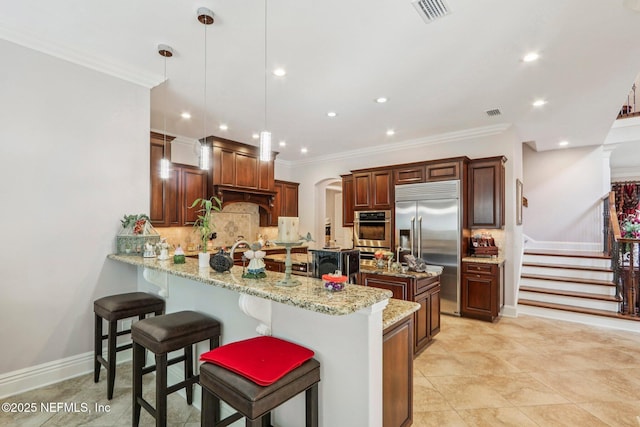 2645 Oakgrove Ave, Saint Augustine, FL 32092 - kitchen featuring appliances with stainless steel finishes, a peninsula, backsplash, arched walkways, and recessed lighting