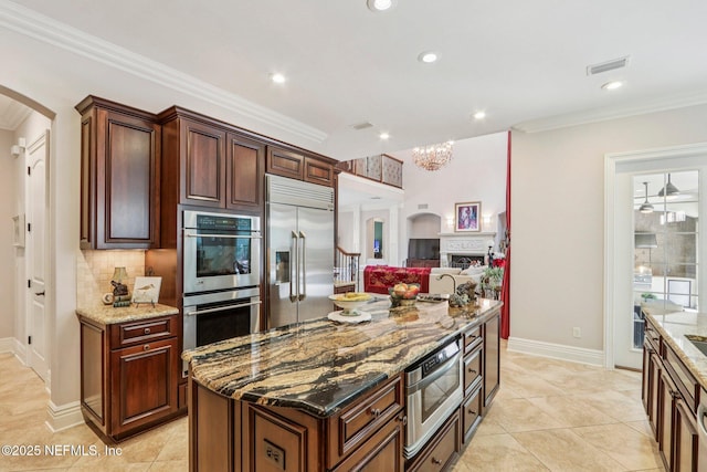 2645 Oakgrove Ave, Saint Augustine, FL 32092 - kitchen with built in appliances, arched walkways, light stone counters, backsplash, and crown molding