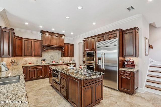 2645 Oakgrove Ave, Saint Augustine, FL 32092 - kitchen featuring stainless steel appliances, a kitchen island, backsplash, light stone countertops, and recessed lighting