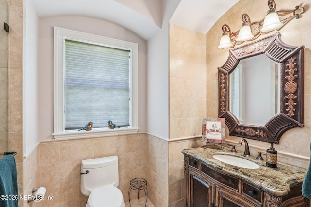 2645 Oakgrove Ave, Saint Augustine, FL 32092 - bathroom featuring tile walls, vanity, healthy amount of natural light, and a wainscoted wall