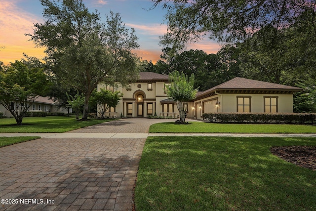 2645 Oakgrove Ave, Saint Augustine, FL 32092 - mediterranean / spanish-style home featuring decorative driveway, stucco siding, a lawn, and an attached garage