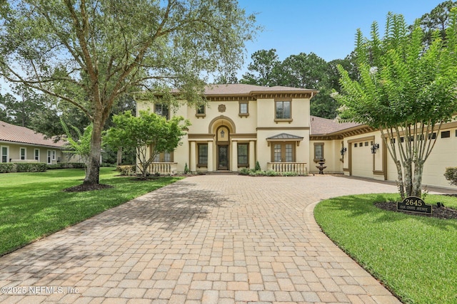 2645 Oakgrove Ave, Saint Augustine, FL 32092 - mediterranean / spanish-style house featuring decorative driveway, stucco siding, a garage, and a front yard