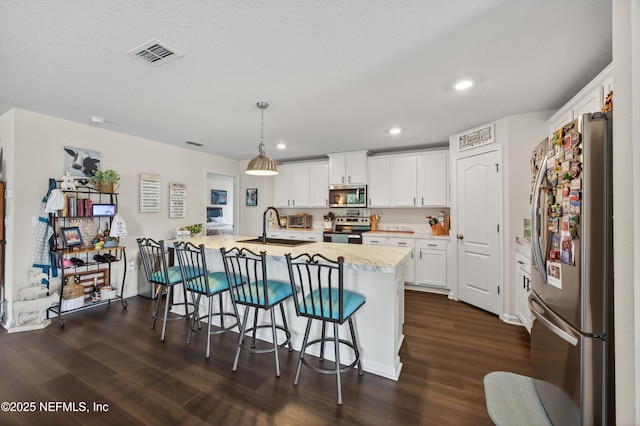 2069 Denton Trce, Green Cove Springs, FL 32043 - kitchen featuring stainless steel appliances, dark wood-style floors, white cabinets, a breakfast bar, and recessed lighting