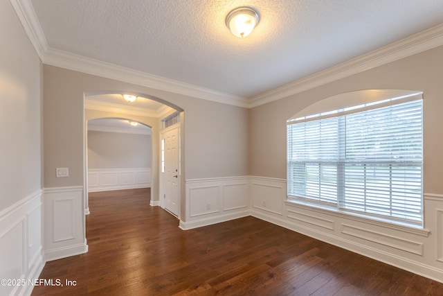 1300 Coopers Hawk Way, Middleburg, FL 32068 - unfurnished room with arched walkways, dark wood-type flooring, crown molding, a wainscoted wall, and a decorative wall