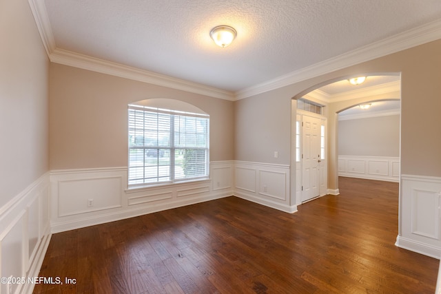 1300 Coopers Hawk Way, Middleburg, FL 32068 - unfurnished room with arched walkways, dark wood-type flooring, wainscoting, crown molding, and a decorative wall