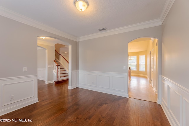 1300 Coopers Hawk Way, Middleburg, FL 32068 - spare room with arched walkways, wood finished floors, ornamental molding, wainscoting, and stairway