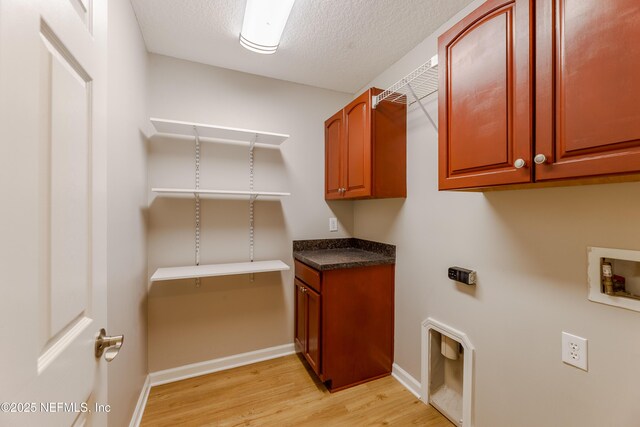 1300 Coopers Hawk Way, Middleburg, FL 32068 - laundry area with washer hookup, light wood finished floors, cabinet space, and a textured ceiling