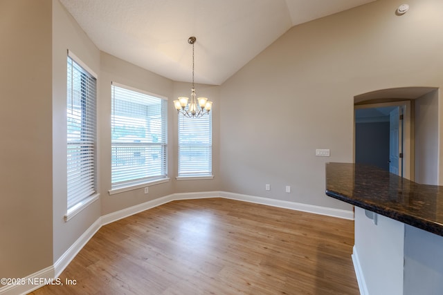 1300 Coopers Hawk Way, Middleburg, FL 32068 - unfurnished dining area with arched walkways, light wood-style floors, a chandelier, and vaulted ceiling