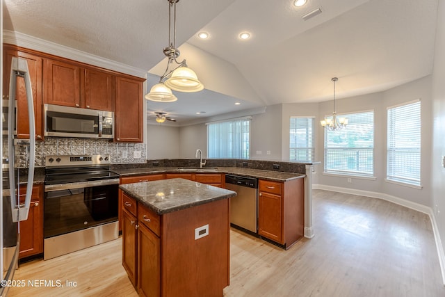 1300 Coopers Hawk Way, Middleburg, FL 32068 - kitchen featuring appliances with stainless steel finishes, a peninsula, light wood-style floors, a chandelier, and brown cabinets