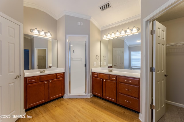 1300 Coopers Hawk Way, Middleburg, FL 32068 - bathroom featuring crown molding, wood finished floors, a spacious closet, two vanities, and lofted ceiling