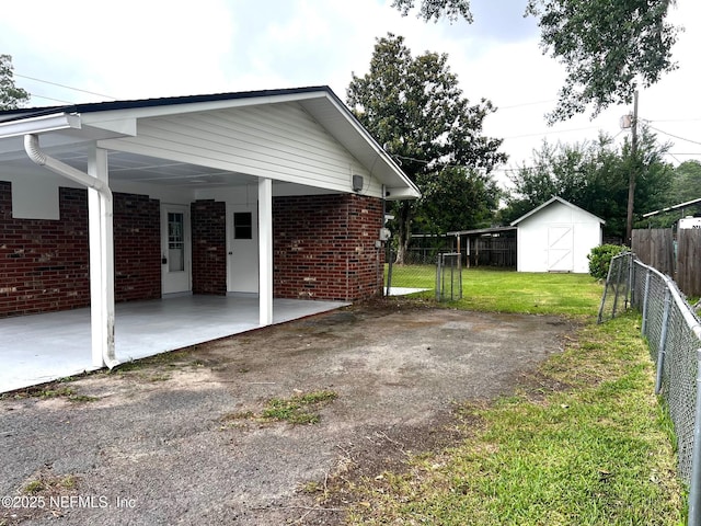 523 Eloise St, Macclenny, FL 32063 - view of property exterior featuring a storage unit, brick siding, an attached carport, and driveway