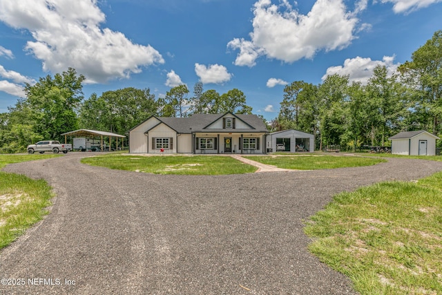 1926 Friendly Pl, Middleburg, FL 32068 - view of front facade with a carport, a porch, a front lawn, gravel driveway, and a storage unit