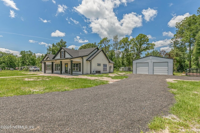 1926 Friendly Pl, Middleburg, FL 32068 - view of front facade featuring a detached garage, an outdoor structure, covered porch, a front lawn, and board and batten siding
