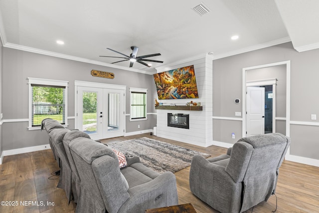 1926 Friendly Pl, Middleburg, FL 32068 - living room with ornamental molding, ceiling fan, a large fireplace, french doors, and wood finished floors