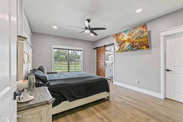 1926 Friendly Pl, Middleburg, FL 32068 - bedroom featuring a barn door, light wood-type flooring, a textured ceiling, recessed lighting, and ceiling fan