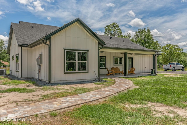 1926 Friendly Pl, Middleburg, FL 32068 - back of house with roof with shingles, board and batten siding, a yard, and covered porch