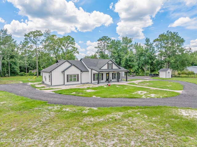 1926 Friendly Pl, Middleburg, FL 32068 - view of front facade featuring a storage unit, covered porch, a front lawn, and view of scattered trees