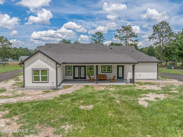 1926 Friendly Pl, Middleburg, FL 32068 - back of house featuring french doors, a shingled roof, a yard, board and batten siding, and a patio area