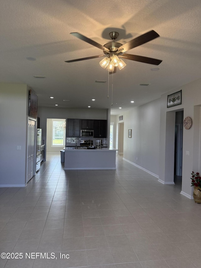 30139 Trophy Trl, Bryceville, FL 32009 - unfurnished living room with a textured ceiling, light tile patterned flooring, ceiling fan, and recessed lighting