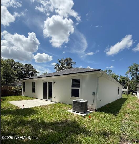 3138 Phyllis St, Jacksonville, FL 32205 - back of property featuring stucco siding, a patio area, and a lawn