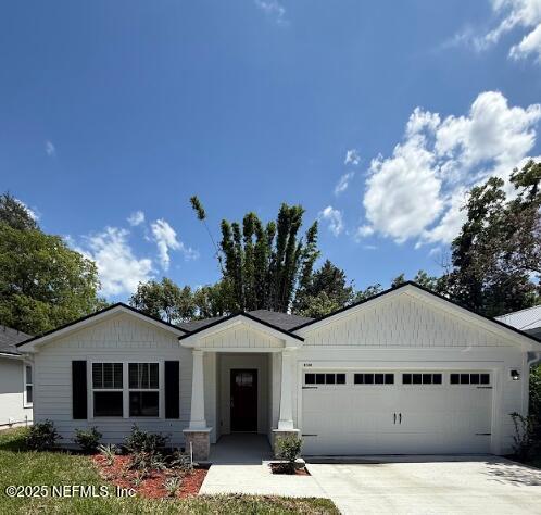 3138 Phyllis St, Jacksonville, FL 32205 - view of front of property featuring a garage, concrete driveway, and board and batten siding