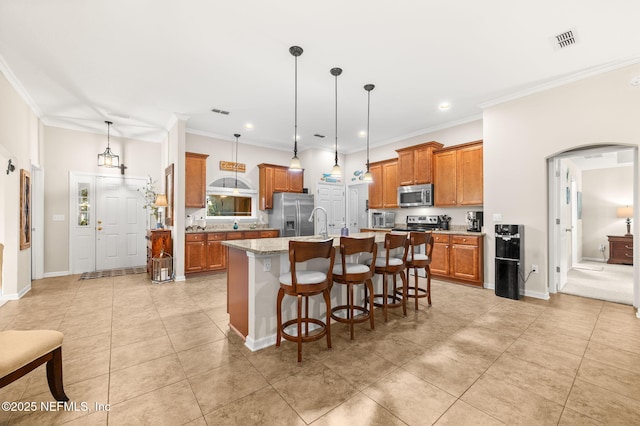 338 Deerfield Glen Dr, Saint Augustine, FL 32086 - kitchen featuring stainless steel appliances, arched walkways, brown cabinetry, crown molding, and a breakfast bar area