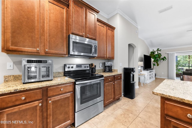 338 Deerfield Glen Dr, Saint Augustine, FL 32086 - kitchen featuring stainless steel appliances, ornamental molding, lofted ceiling, light tile patterned floors, and light stone countertops