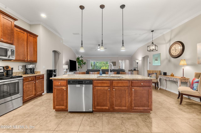 338 Deerfield Glen Dr, Saint Augustine, FL 32086 - kitchen featuring appliances with stainless steel finishes, crown molding, hanging light fixtures, brown cabinetry, and a center island with sink