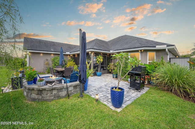 338 Deerfield Glen Dr, Saint Augustine, FL 32086 - back of house at dusk with a patio, a fire pit, and a yard