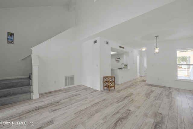 1206 Mayport Landing Cir, Jacksonville, FL 32233 - unfurnished living room with hardwood / wood-style floors, stairs, and a towering ceiling