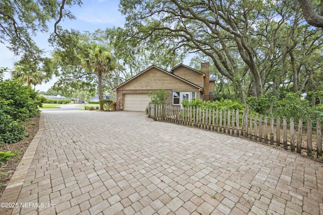 521 Birch Ct, Neptune Beach, FL 32266 - view of side of home featuring a chimney, an attached garage, decorative driveway, and brick siding