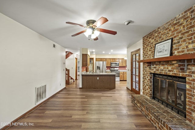 521 Birch Ct, Neptune Beach, FL 32266 - living room with ceiling fan, a fireplace, dark wood-style flooring, and stairway