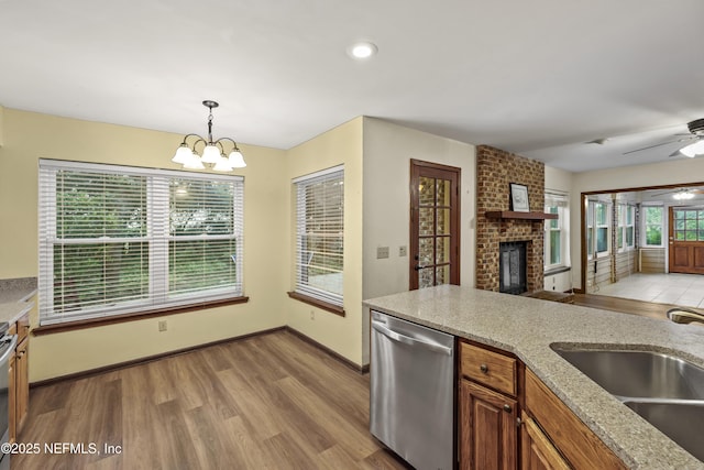 521 Birch Ct, Neptune Beach, FL 32266 - kitchen featuring stainless steel dishwasher, a fireplace, open floor plan, a chandelier, and light wood-type flooring
