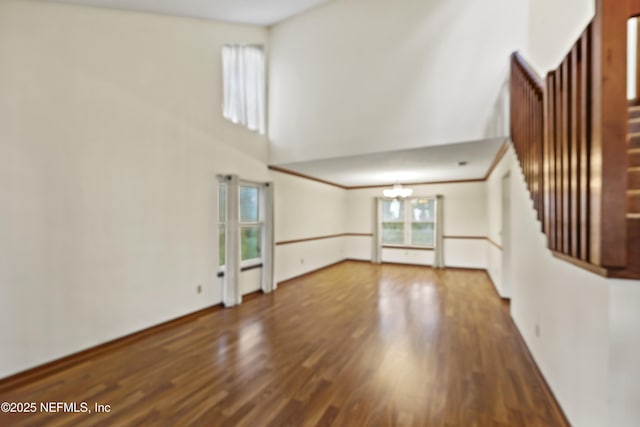 521 Birch Ct, Neptune Beach, FL 32266 - unfurnished living room with stairway, a chandelier, wood finished floors, and a high ceiling