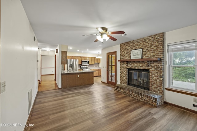 521 Birch Ct, Neptune Beach, FL 32266 - unfurnished living room with ceiling fan, wood finished floors, and a brick fireplace