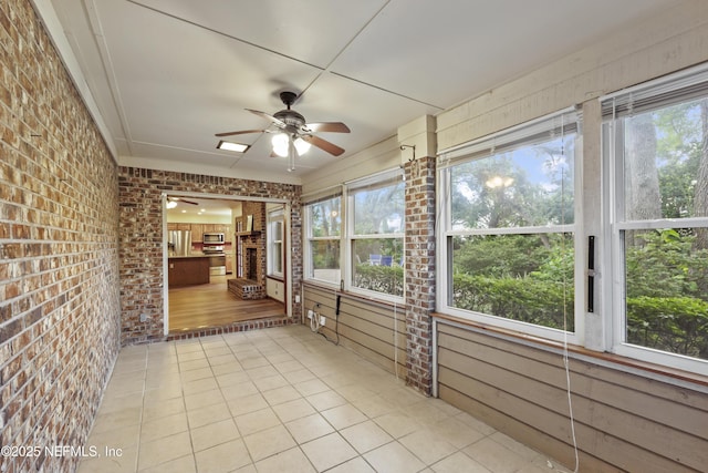 521 Birch Ct, Neptune Beach, FL 32266 - unfurnished sunroom with brick wall, ceiling fan, healthy amount of natural light, and tile patterned floors