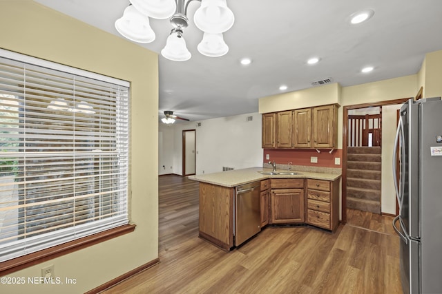 521 Birch Ct, Neptune Beach, FL 32266 - kitchen featuring stainless steel appliances, a peninsula, brown cabinets, light wood-style floors, and recessed lighting